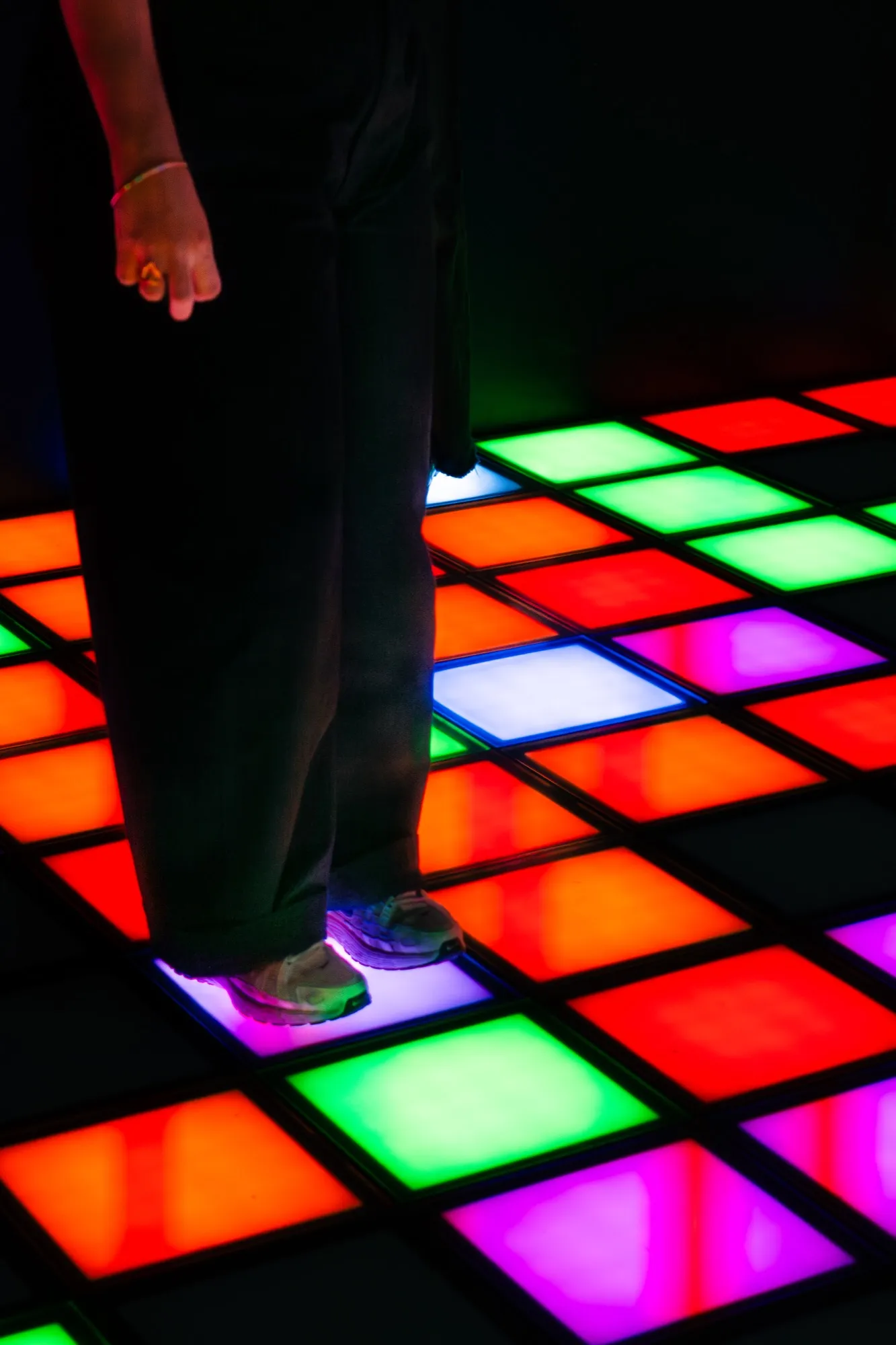 Joueur sur les dalles multicolores de la salle PIXEL ROOM