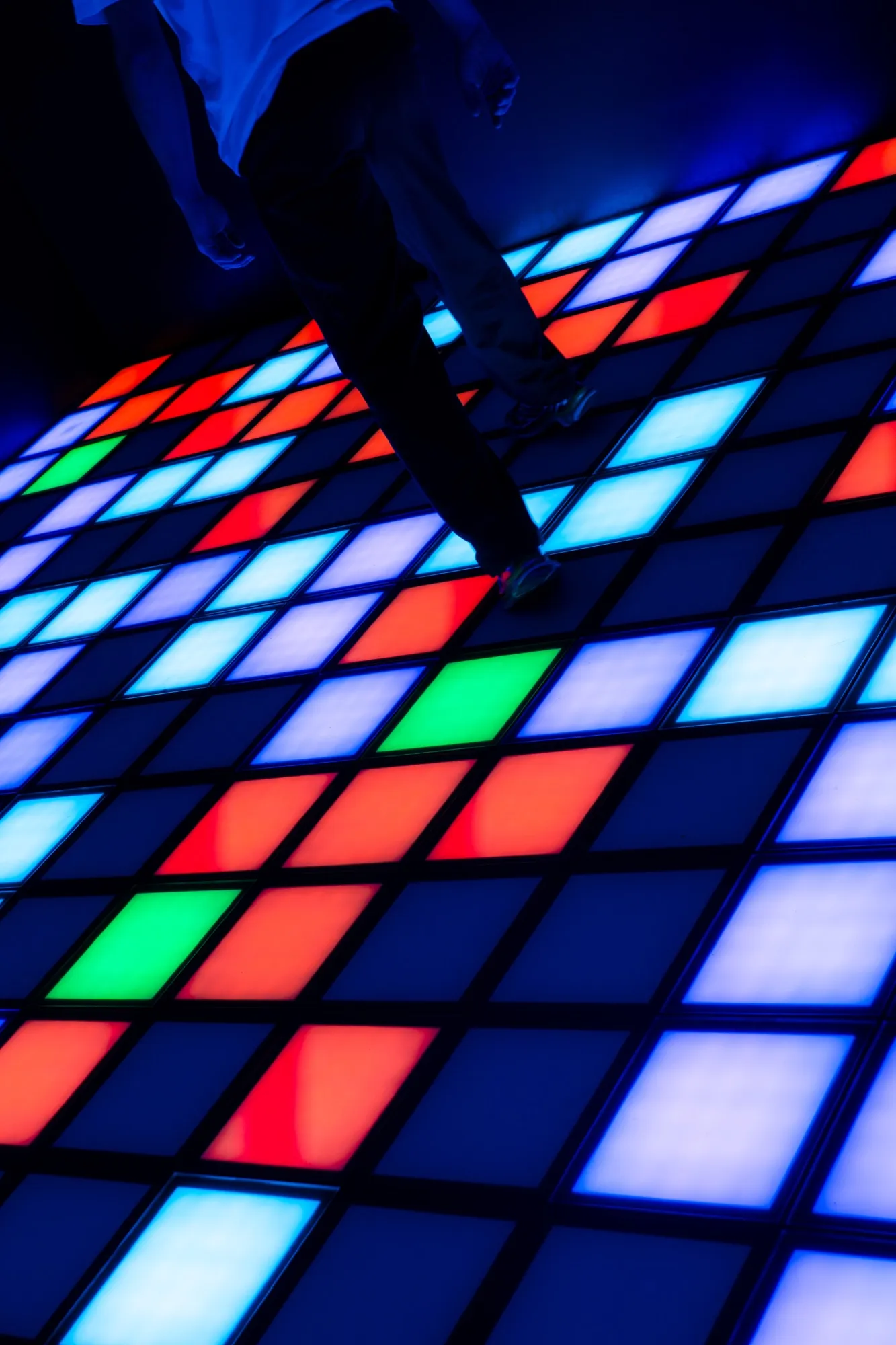 Joueur en pleine partie sur le sol de dalles lumineuses PIXEL ROOM